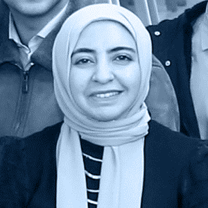 A woman wearing a scarf is smiling warmly.