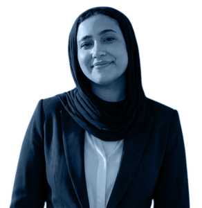 Professional portrait of a woman wearing a hijab and a dark blazer